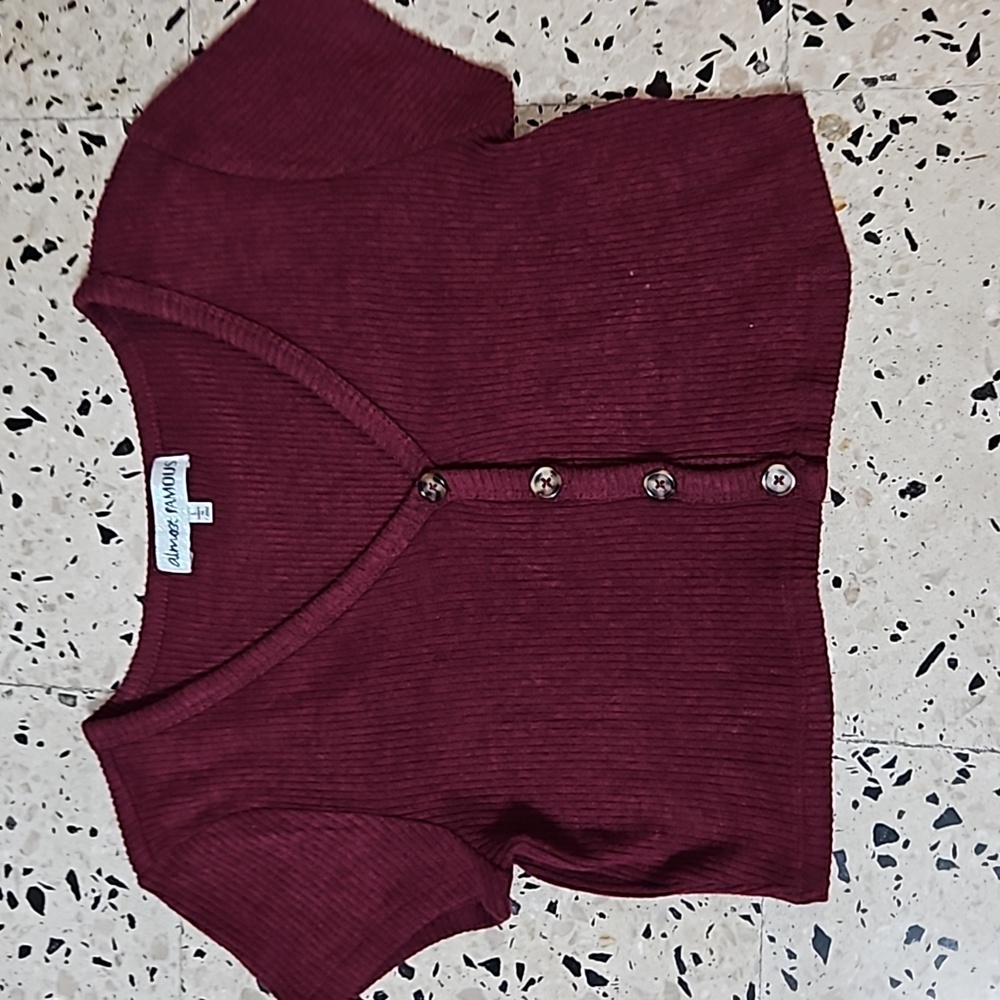 A burgundy button crop top from the brand almost famous